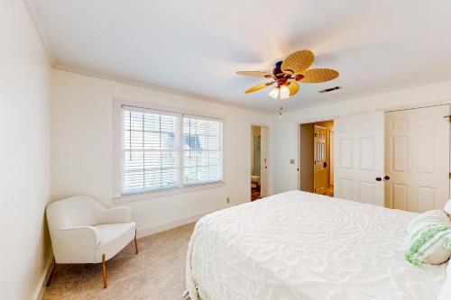 a bedroom with a white bed and a ceiling fan at Three Kings in Demere Park
