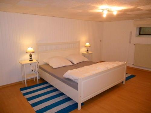 a bedroom with a white bed and two night stands at FeWo Wichmanninklusive Strandkorb am Meer free WLAN bis 6 Personen, Platz für Ihre Fahrräder in Grömitz