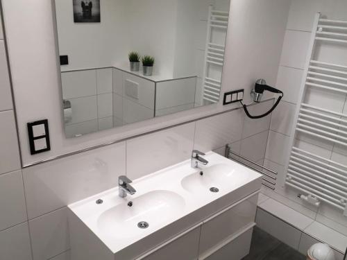 a white bathroom with a sink and a mirror at FeWo Wichmanninklusive Strandkorb am Meer free WLAN bis 6 Personen, Platz für Ihre Fahrräder in Grömitz