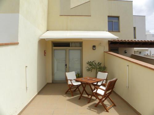 a patio with a table and chairs on a balcony at El Carmen in El Cotillo