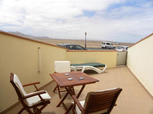 a patio with chairs and a table on a balcony at El Carmen in El Cotillo