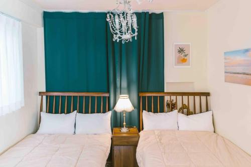 2 camas en un dormitorio con cortina verde en Space Epiphany, en Seúl