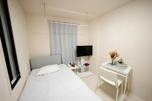 - une chambre blanche avec un lit et un bureau dans l'établissement FL Rejidence Shinjuku 2 - Vacation STAY 15187, à Tokyo