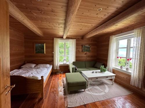 a bedroom with a bed and a couch and a table at Drengastova Hardangerfjord in Lofthus