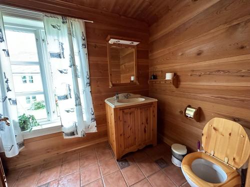 a wooden bathroom with a sink and a toilet at Drengastova Hardangerfjord in Lofthus