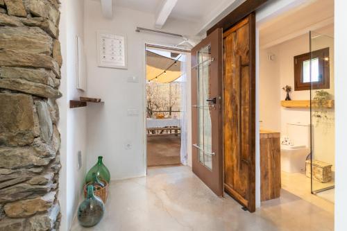 korytarz z drzwiami i kamienną ścianą w obiekcie El Roure w mieście Molló