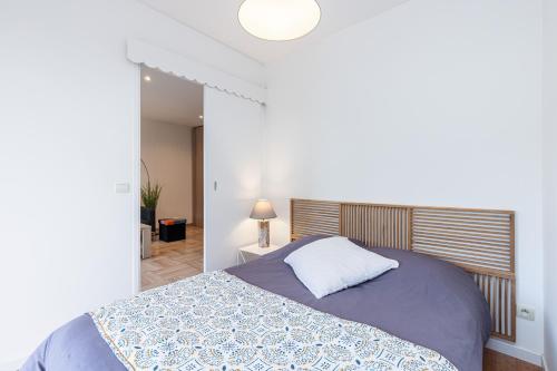 a bedroom with a bed with a blue and white blanket at Antipolis in Cros-de-Cagnes