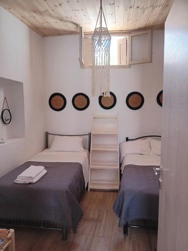 a bedroom with two beds and a chandelier at Vasiliki Skyros Castle View in Skiros