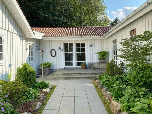 a white house with a pathway leading to the front door at Idyllically Situated Wooden House By The Forest in Viborg