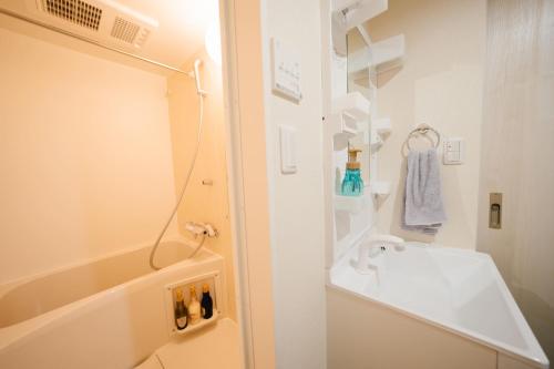 a white bathroom with a shower and a sink at FL Rejidence Shinjuku 2 - Vacation STAY 15191 in Tokyo