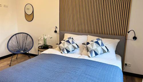 a bedroom with a bed with a blue blanket and pillows at Große Wohnung Wellness + Sauna + Netflix in Petershagen