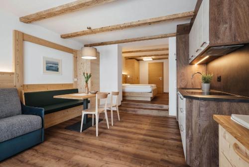 バディーアにあるApartments Roda de Ciarのソファとテーブルのあるキッチンとリビングルーム