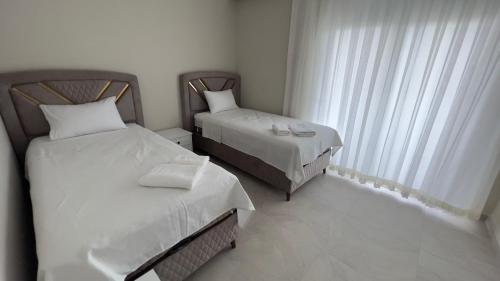 加濟帕夏的住宿－GAZİPAŞA SELİNTİ CİTY DUBLEX 2 Oda，一间卧室设有两张床和窗户。