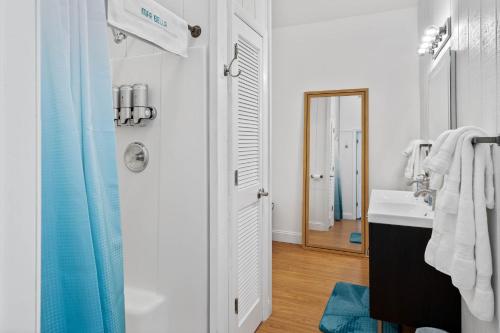 La salle de bains blanche est pourvue d'un lavabo et d'un miroir. dans l'établissement Mar Bella Boutique Hotel, à Rehoboth Beach
