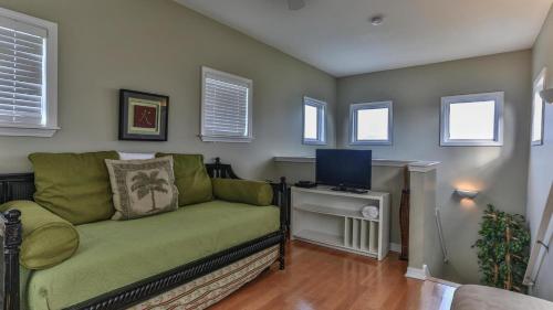 a living room with a couch and a tv at Biglows Bungalow - About a quarter mile to PRIVATE Neighborhood Beach Access, Pet Friendly, Community Pool in Destin