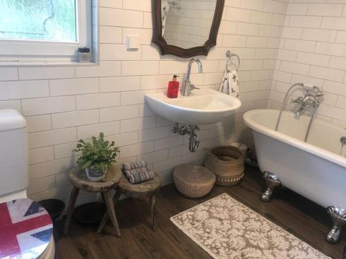 a bathroom with a sink and a bath tub at Home Sweet Vacation Home in Ledenitzen