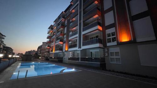 a building with a swimming pool in front of it at GAZİPAŞA SELİNTİ CİTY DUBLEX 2 Oda in Gazipasa