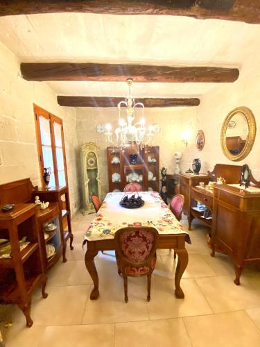 a dining room with a table and a chandelier at VINTAGE FARMHOUSE in Qormi