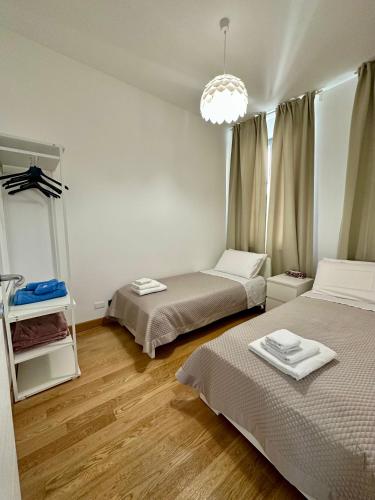 a bedroom with two beds and a chandelier at Due Passi dal Porto in Genova
