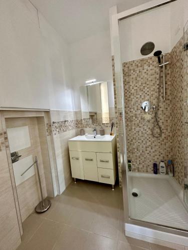 La salle de bains est pourvue d'un lavabo et d'une douche. dans l'établissement Due Passi dal Porto, à Gênes