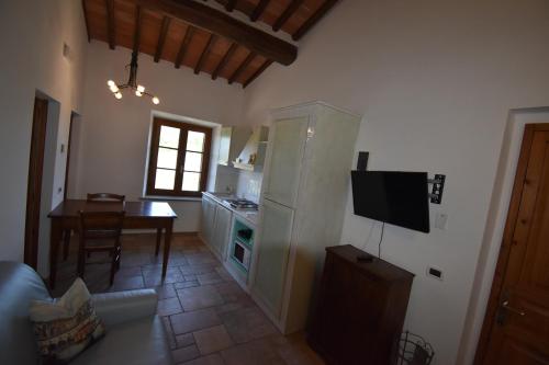 a kitchen and dining room with a table and a television at Falesta in Casole dʼElsa
