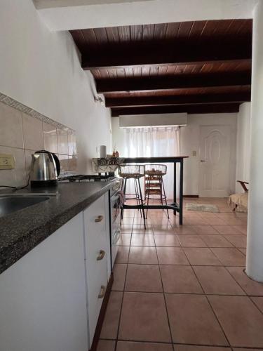 a kitchen with a table and a counter top at Complejo Alberdi depto 8 in Tandil