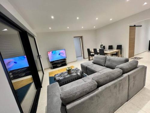 uma sala de estar com um sofá e uma televisão de ecrã plano em Maison centre-ville em Penta-di-Casinca