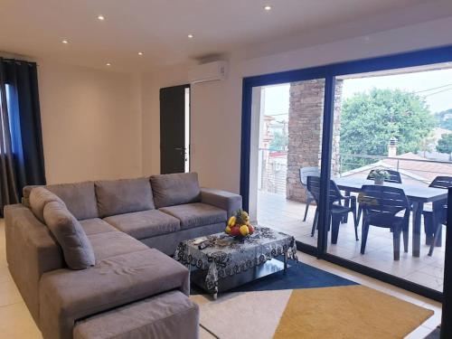 een woonkamer met een bank en een tafel bij Maison centre-ville in Penta-di-Casinca