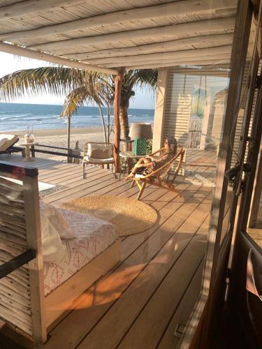 a person sitting on a deck on the beach at KiChic in Máncora