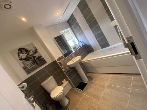 een badkamer met een toilet, een wastafel en een bad bij The Belfry 3 Bedrooms 2 Bathrooms Contractors & Family in Higham Ferrers