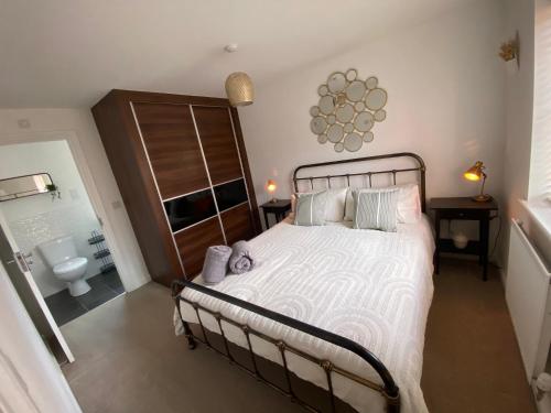 1 dormitorio con 1 cama grande y baño en The Belfry 3 Bedrooms 2 Bathrooms Contractors & Family, en Higham Ferrers