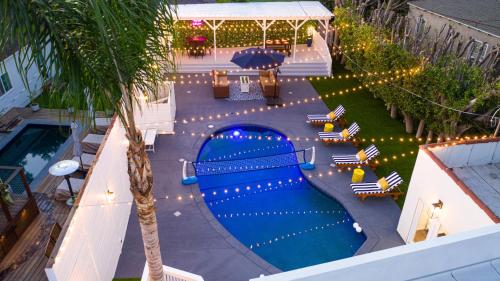 una vista aérea de una piscina con sillas y una palmera en Studio City Contemporary Villa with Pool Sleeps 10 en Los Ángeles