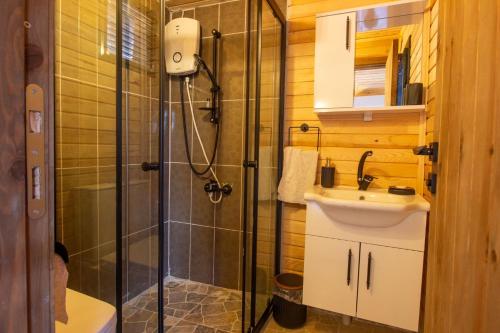 uma casa de banho com um chuveiro, um lavatório e um WC. em Reflections Camp em Faralya