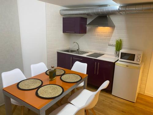 uma pequena cozinha com uma mesa e cadeiras brancas em ESPACIO19 em Córdoba