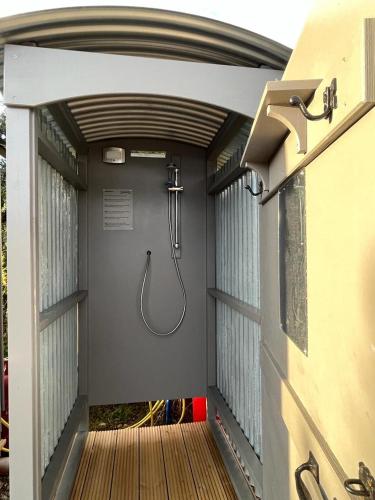 a shower in the back of a building at Gresham Hall Glamping in Aylmerton
