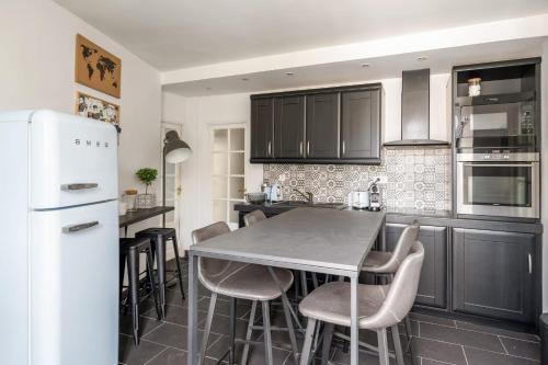 La cuisine est équipée d'une table, de chaises et d'un réfrigérateur. dans l'établissement Superb flat in the heart of Montmartre - Welkeys, à Paris