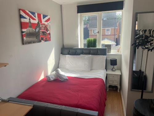 a small bedroom with a bed with a red blanket at FilmonHomes in Oldbury