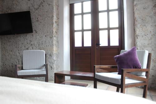 El Encanto في بوبلا: غرفة بها كرسيين وطاولة وباب