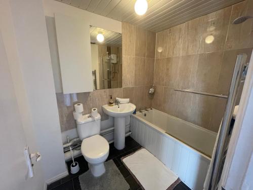 a bathroom with a toilet and a sink and a tub at FilmonHomes in Oldbury