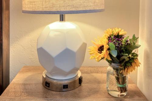a lamp sitting on a table next to a vase of flowers at Desert Gardens #1 in Moab