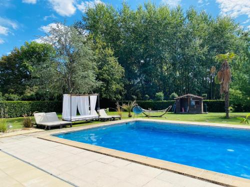 - une piscine avec 2 chaises longues et un hamac dans l'établissement Gîte E & M, à Saint-Denis-de-Pile