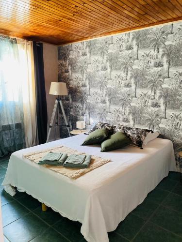 - une chambre avec un lit et un mur orné de palmiers dans l'établissement Gîte E & M, à Saint-Denis-de-Pile