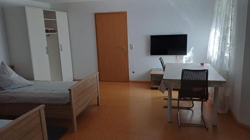 Habitación con cama, mesa y escritorio. en Ferienwohnung Funkner, 