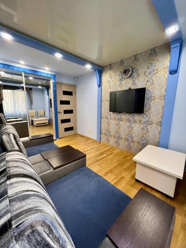 a living room with a couch and a tv at Avenue Apart in Lviv