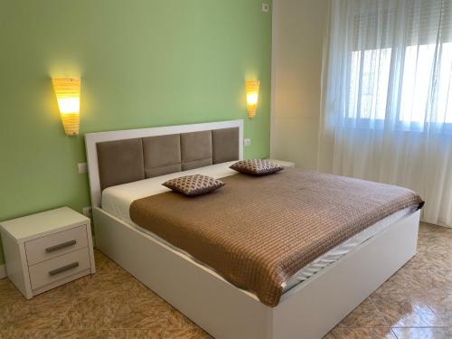 a bedroom with a bed with two pillows on it at Adelina's Delux Apartament Durres in Durrës