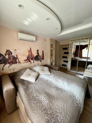 a bedroom with a large bed with horses on the wall at Avenue Apart in Lviv