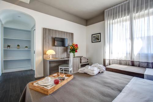 a bedroom with a bed and a table and a desk at Hotel Cristallo in Cattolica
