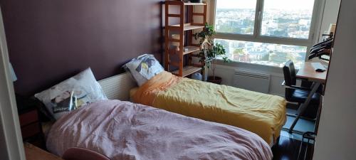 a room with two beds and a window and a desk at Full apt - Top floor - Eiffel Tower Panoramic View in Issy-les-Moulineaux