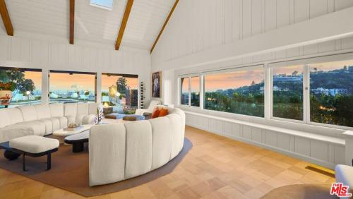 a living room with white furniture and large windows at Beverly Estates in Los Angeles