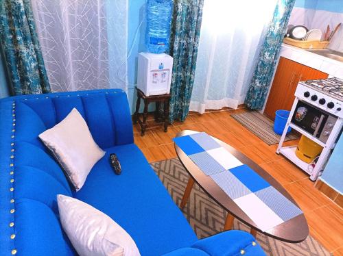 奈瓦沙的住宿－Devine Studio in Naivasha Town，客厅配有蓝色的沙发和滑板